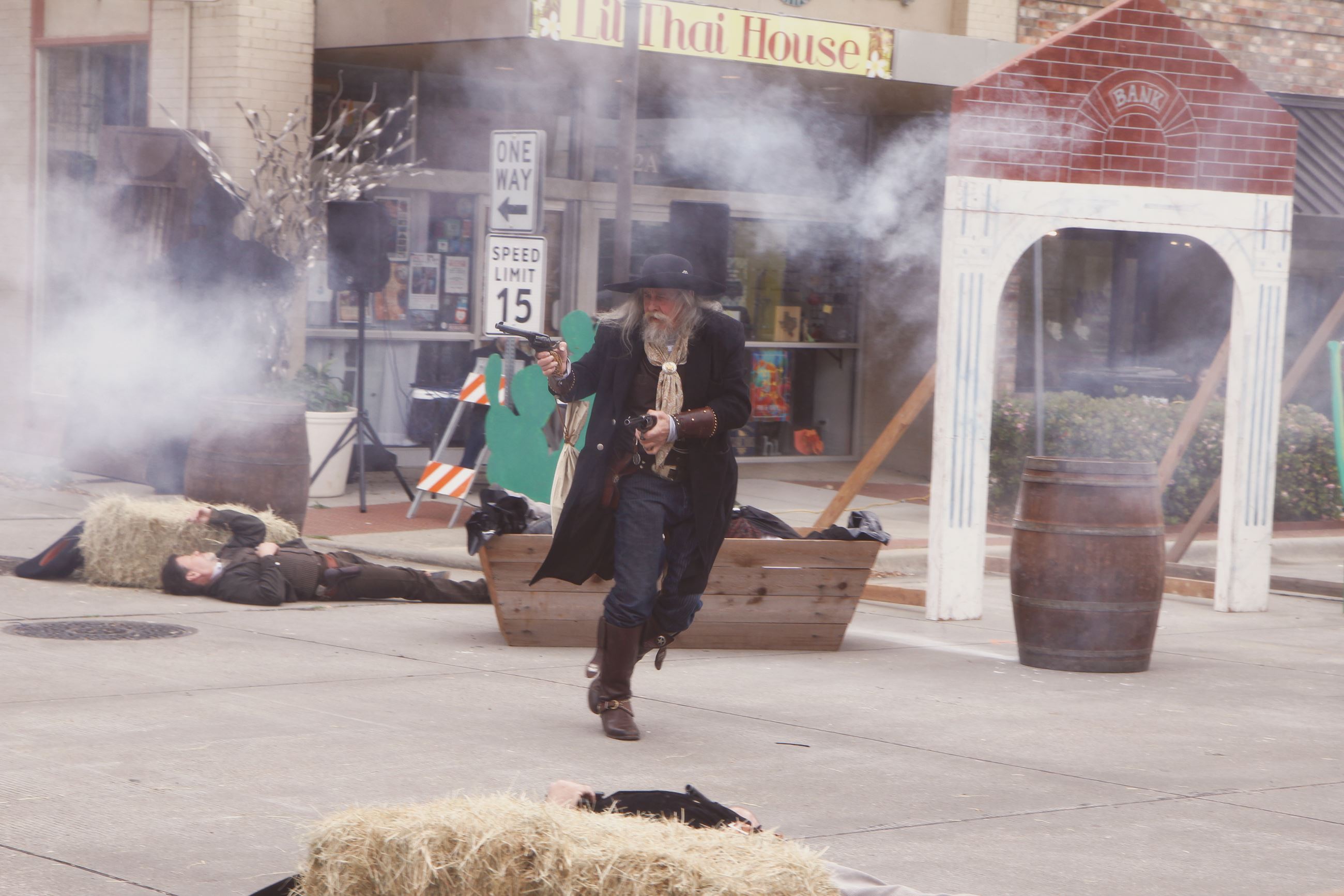 Dalton Days Reenactment including a man dressed in western wear holding two firearms acting out